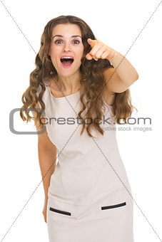 Surprised young woman pointing in camera