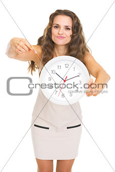 Concerned young woman pointing on clock