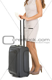 Closeup on young tourist woman with wheel bag and air tickets