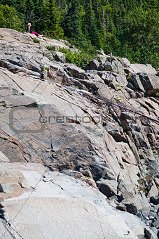 Girl sitting on a huge rock