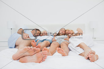 Two parents sleeping with their two children