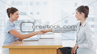 Businesswoman shaking hands with interviewee