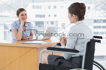 Businesswoman listening to disabled job candidate