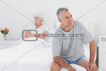 Angry man sitting in bed during a dispute