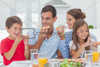 Happy family eating pizza slices