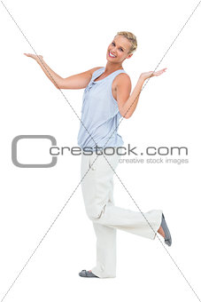 Happy woman standing with hands up and leg raised