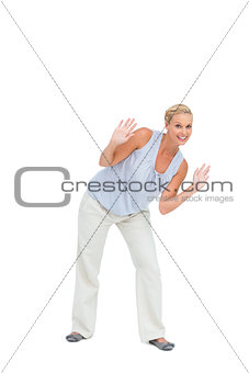 Blonde woman bending down with hands up