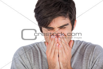 Young man sneezing