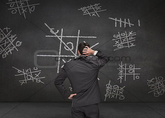 Thoughtful businessman looking at Tic-tac-toe game