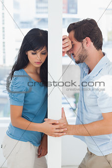 Couple are separated by white wall