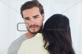 Woman giving hug to uninterested boyfriend
