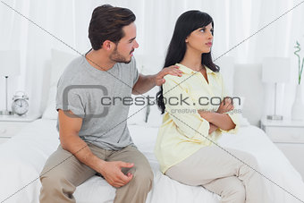 Woman sulking while her boyfriend is trying to make up