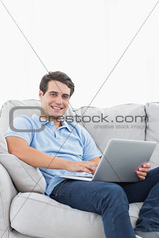 Portrait of a cheerful man using his laptop