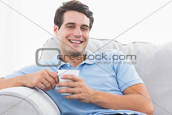 Portrait of a cheerful man holding a cup of coffee