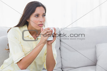Thoughtful woman holding a cup of coffee