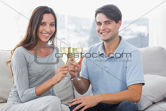 Portrait of lovers clinking their flutes of champagne