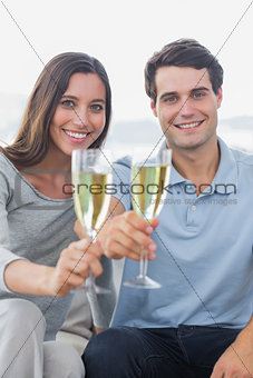 Portrait of a couple toasting their flutes of champagne