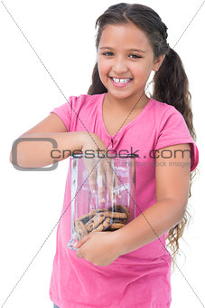 Little girl taking a cookie from jar