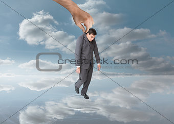 Big hand holding a businessman by his jacket