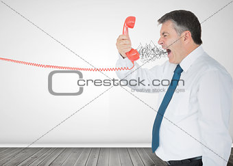 Mature businessman screaming on the phone