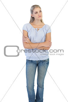Thinking blonde woman crossing her arms