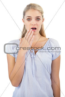 Shocked blonde woman with hand in front of her mouth