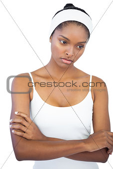 Troubled woman with headband crossing her arms