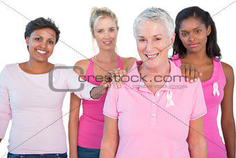 Supportive group of women wearing pink tops and breast cancer ribbons