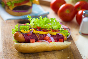 hot dog and bacon served with mustard tomatoes and plenty of bac