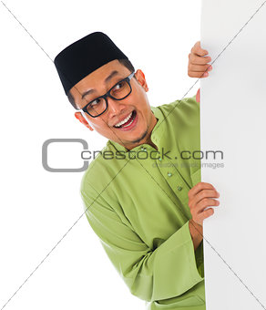 malay male with blank card during hari raya Eid al-Fitr celebrat