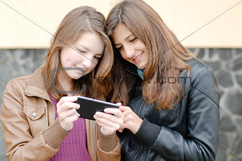 Two teen girls looking on tablet pc