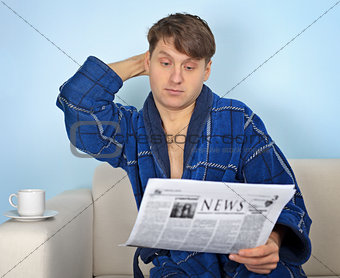 Person reads a newspaper with pensiveness