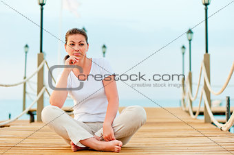 beautiful girl resting on a pier at dawn