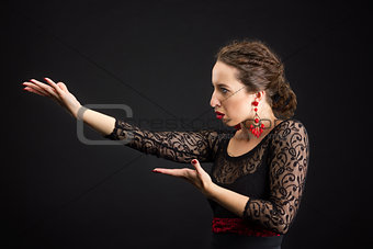 Portrait of spanish woman dancing flamenco on black
