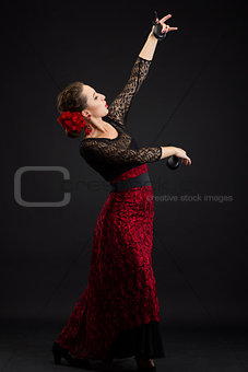 Spanish woman dancing flamenco on black