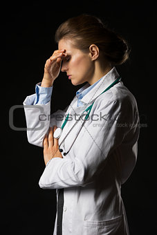 Portrait of frustrated doctor woman isolated on black