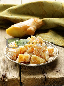 sugared ginger (candied) and fresh root on a wooden table