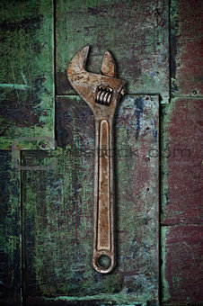 Old wrench on rusty surface.