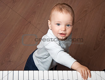 child  play music on piano keyboard