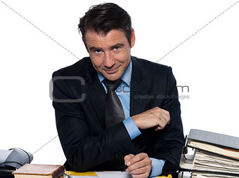Man businessman writing sitting a desk looking at camera