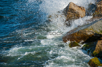 wave hitting stones