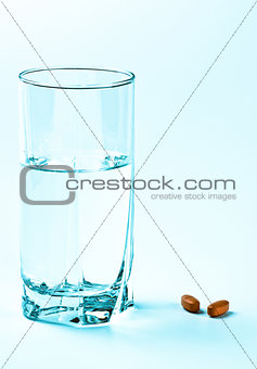 two tablets and glass of water 