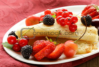 thin dessert pancakes (crepes) with various berries