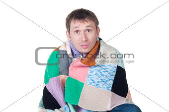man wrapped in a warm blanket shivering from the cold