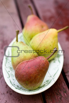 Tasty fragrant pear lying on a white plate