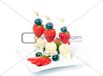 Canapes on a plate with cheese melon and strawberries