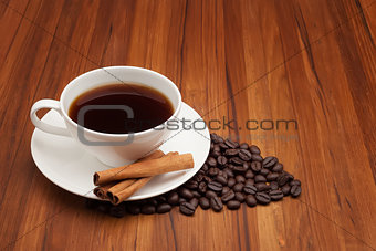 Coffee cup with cinnamon stick on wood table