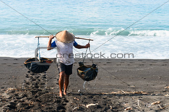 Traditional sea salt production on the volcanic black sand, Bali