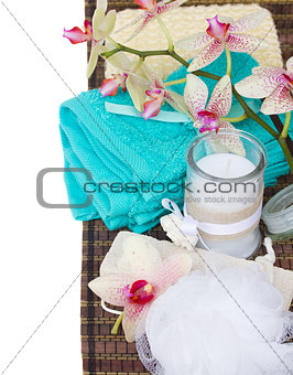 spa setting with blue towels, aroma candle and bath accessories