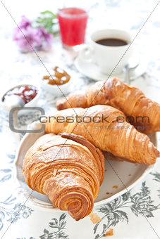 Croissants on table with jam, orange juice and coffee